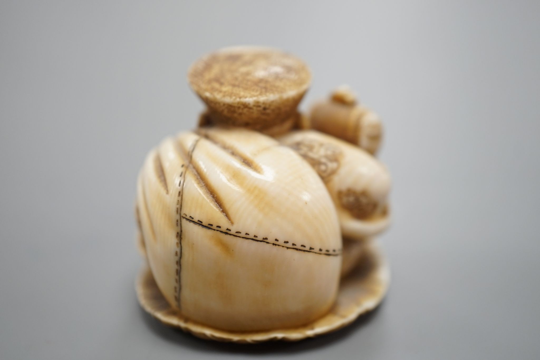 A Japanese ivory netsuke of Daikoku, Meiji period, 3 cms high.